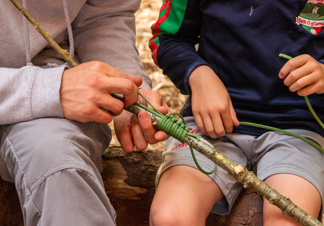 Man teaching boy knots