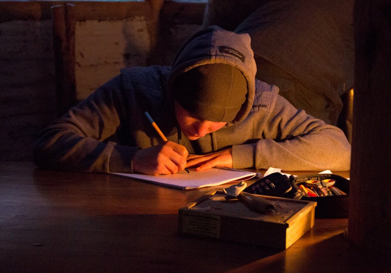 Boy doing an exam by candle light