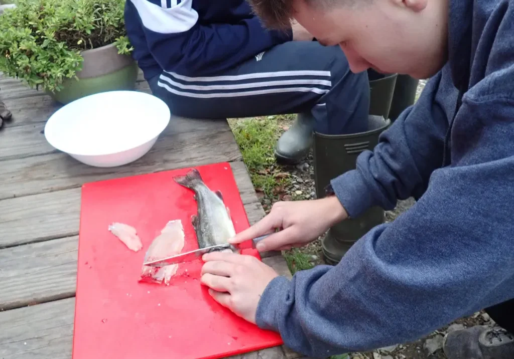Boy filleting fish
